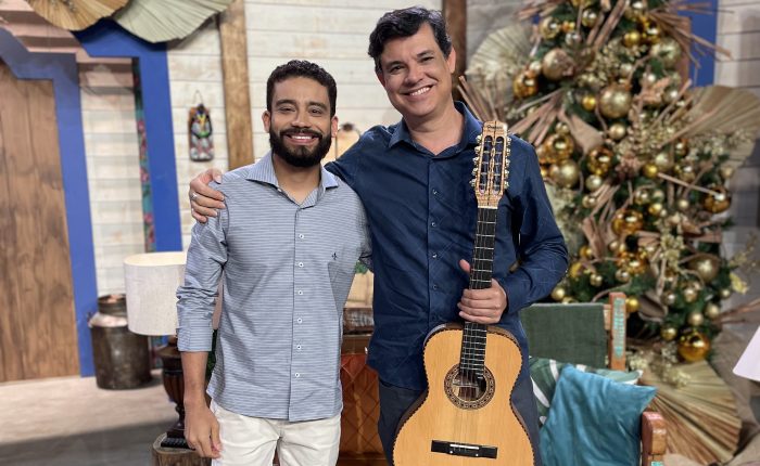 Yassir Chediak segurando sua viola de 10 cordas ao lado do Padre Paulinho